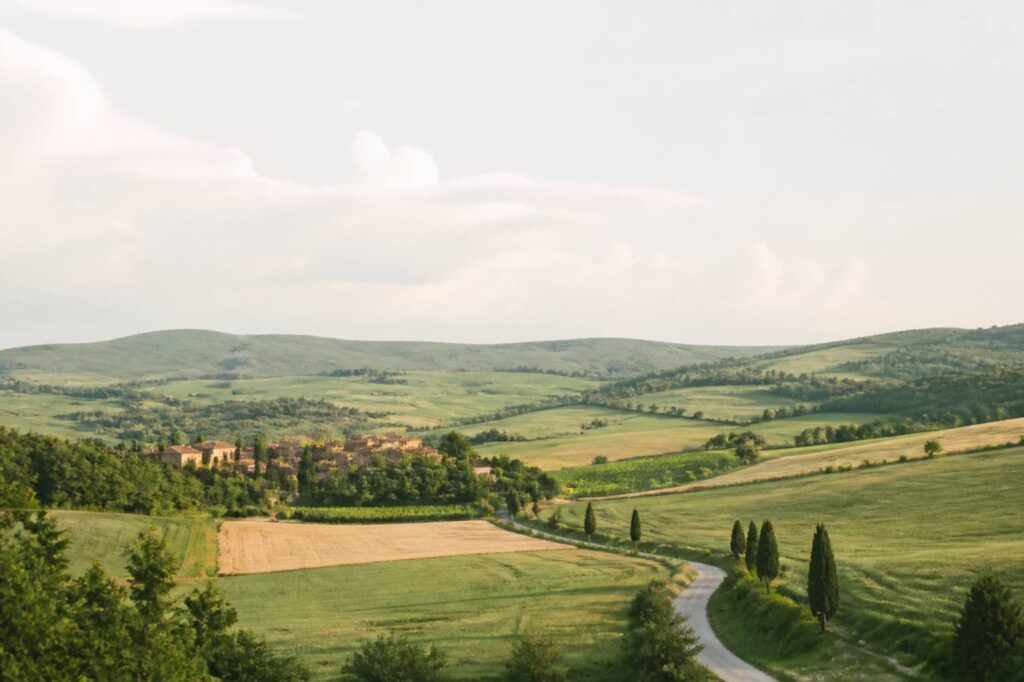 Paysage de région française avec collines verdoyantes, village aux toits de tuiles et champs cultivés