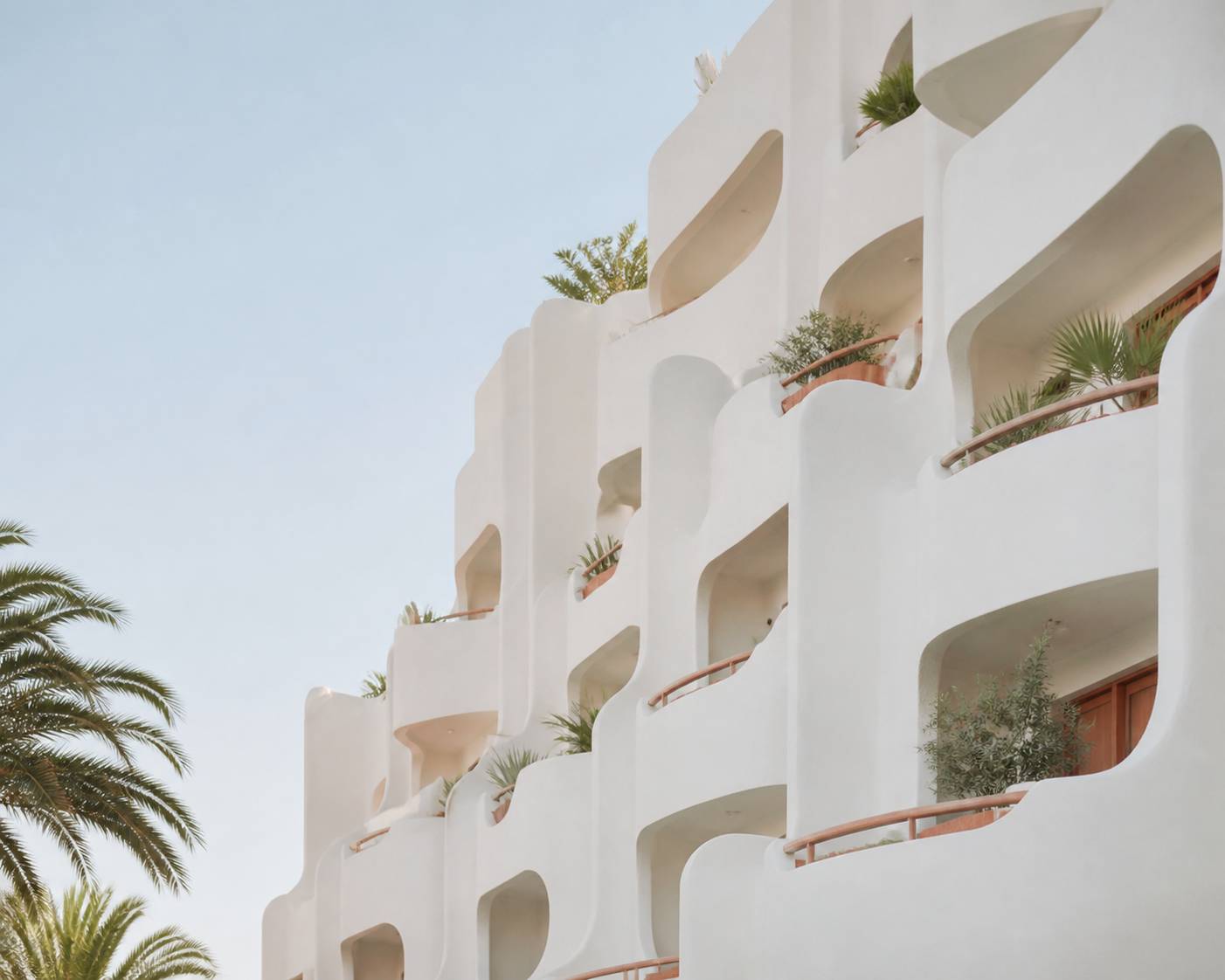 Façades blanches incurvées d'un immeuble pyramidal avec balcons
