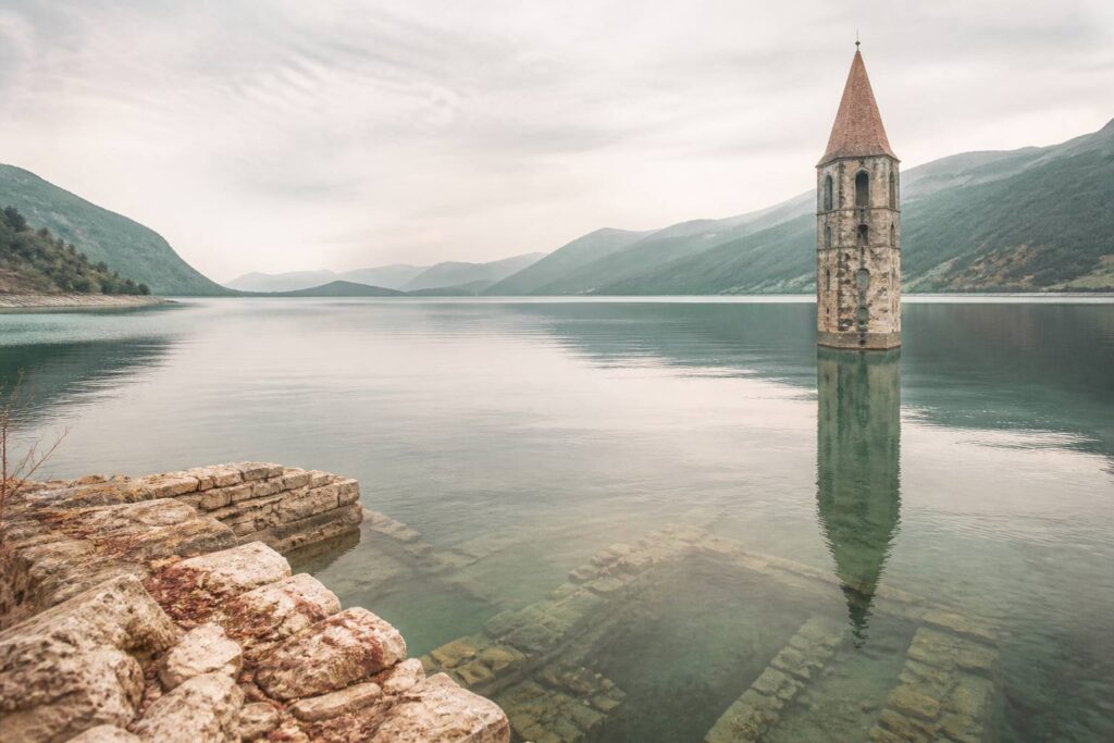 Clocher d'église émergeant des eaux calmes d'un lac de barrage